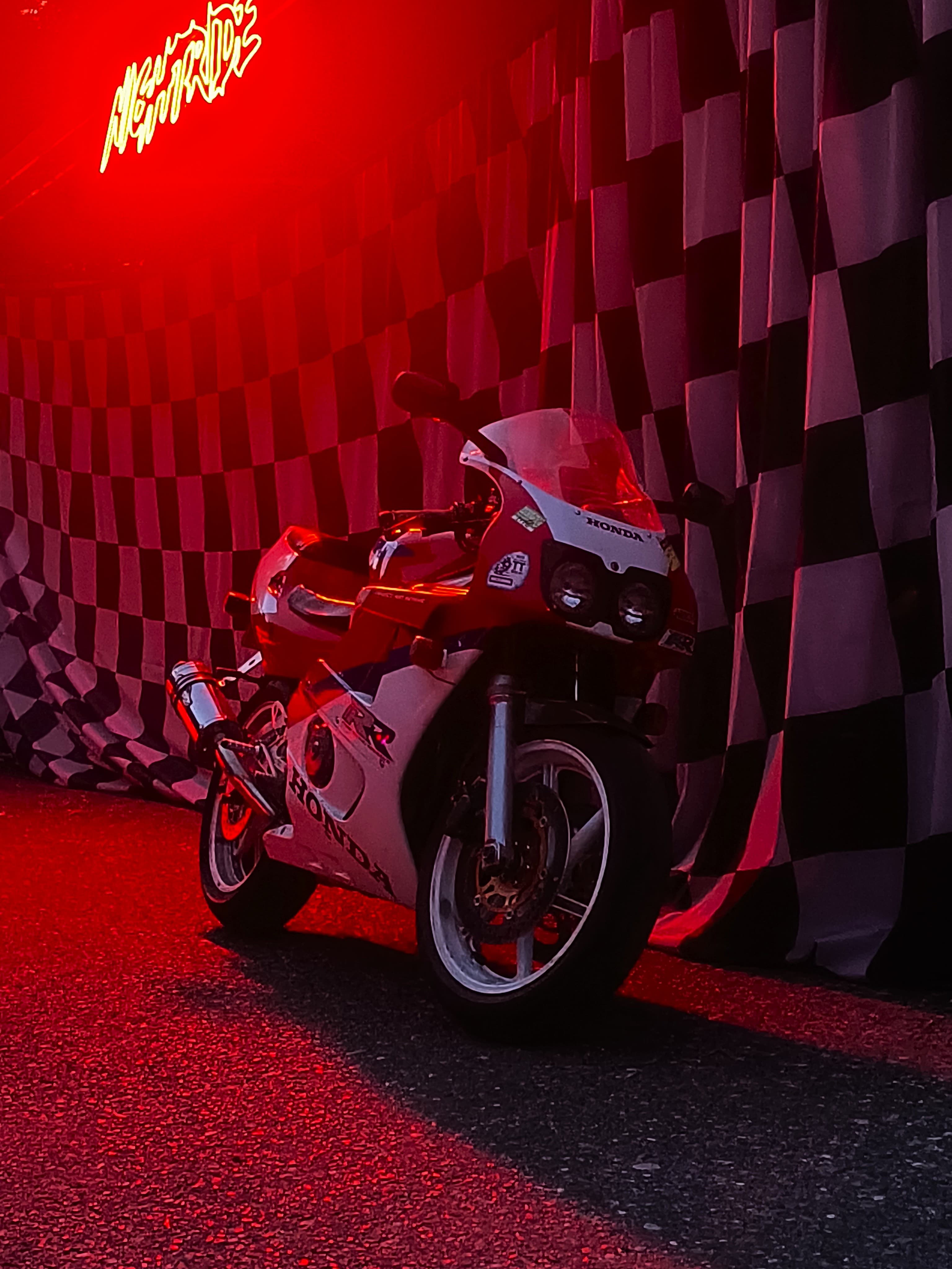 A Honda CBR motorcycle with neon sign in the background