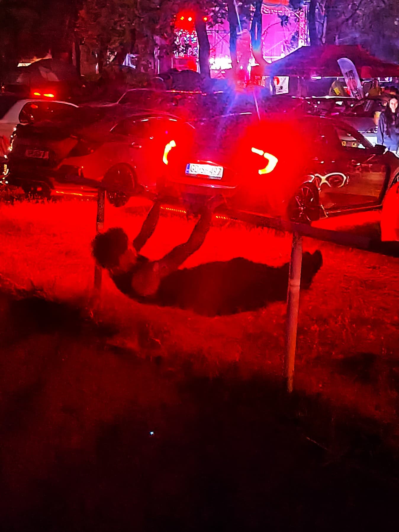 A calisthenic doing front lever in the light of a car